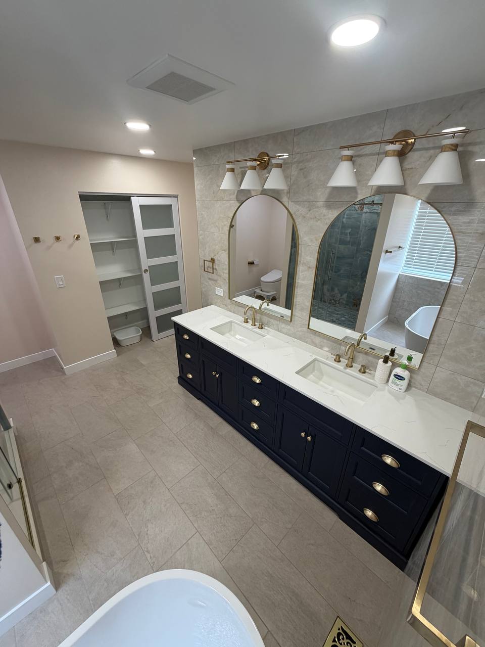Navy double vanity with arched mirrors and gold hardware, Round Lake